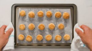 Freshly Baked Coconut Macaroons with Golden Brown Tops Are Shown on A Parchment-Lined Baking Sheet
