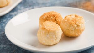Three Golden Coconut Macaroons Are Served on A White Plate, Fully Cooled and Ready to Eat