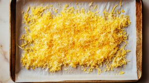Fresh lemon zest spread evenly on a parchment-lined baking sheet, ready for drying