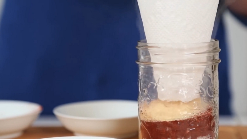 Baking Mix Jar being filled through a paper funnel with pre-measured dry ingredients