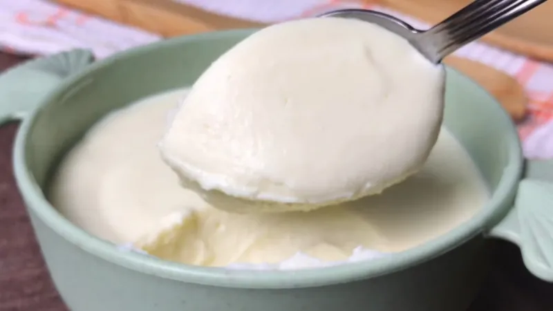 A spoonful of smooth plain yogurt thinned with milk, ready to use as a buttermilk substitute in baking