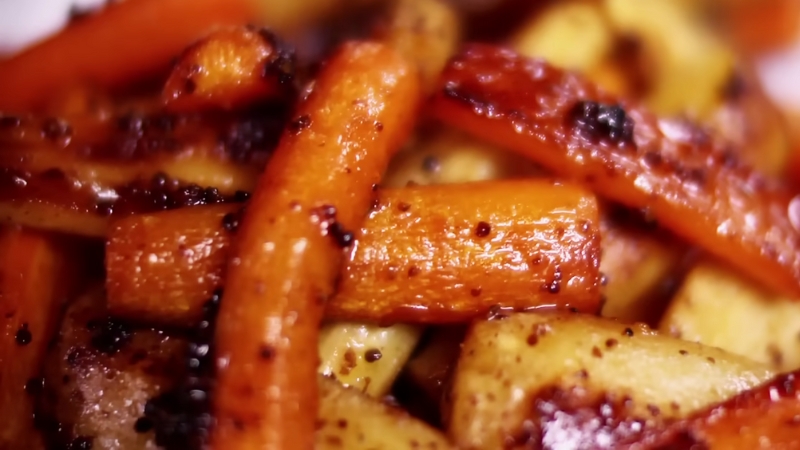 Roasted carrots and potatoes are coated in a glossy glaze made with leftover jam or fruit preserves