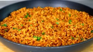 Fluffy seasoned rice garnished with chopped cilantro in a black skillet, ready to serve