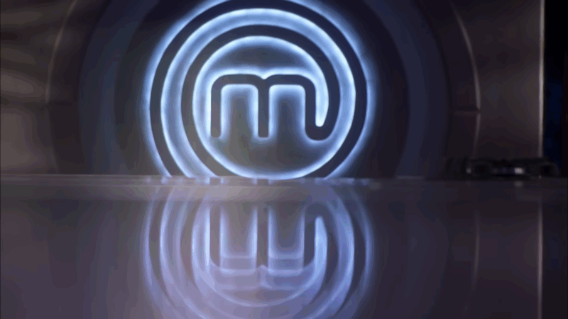 The MasterChef logo glows on the studio floor before the cooking challenge begins