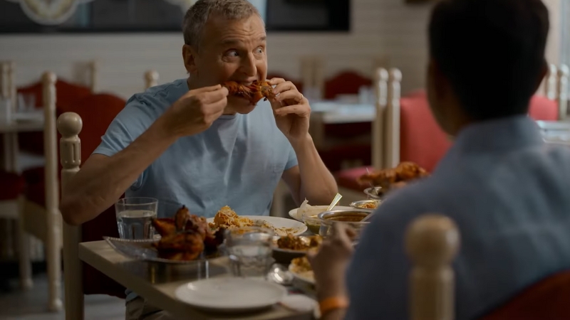 Phil Rosenthal enjoys a plate of spicy grilled chicken during a restaurant visit in Somebody Feed Phil