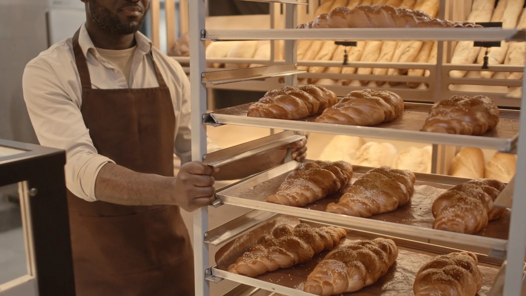 Baker preparing fresh bread for display