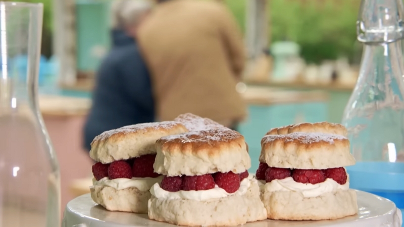 Freshly baked scones filled with cream and raspberries sit ready for judging on The Great British Bake Off
