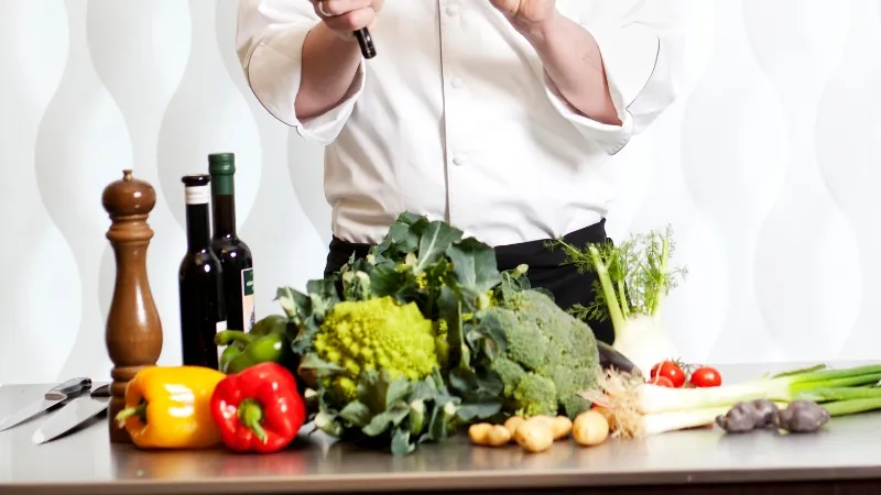 A chef prepares to cook with fresh vegetables and oils, capturing the energy of today’s most addictive cooking shows