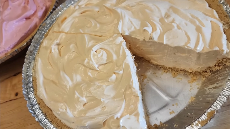 A creamy orange no-bake Kool-Aid pie with a slice removed