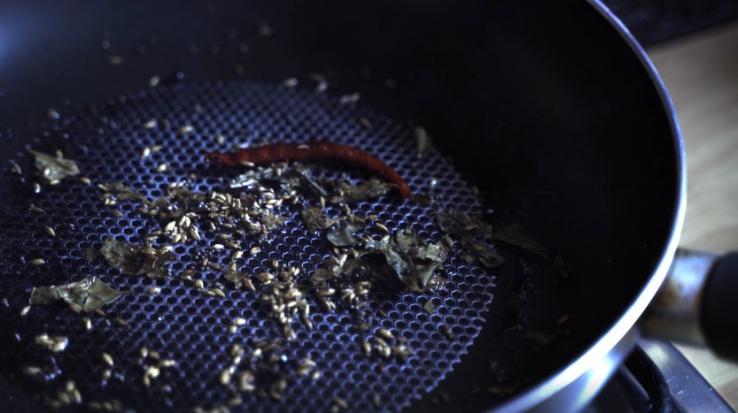 Aromatic spices sizzling in a hot pan, releasing their fragrant essence